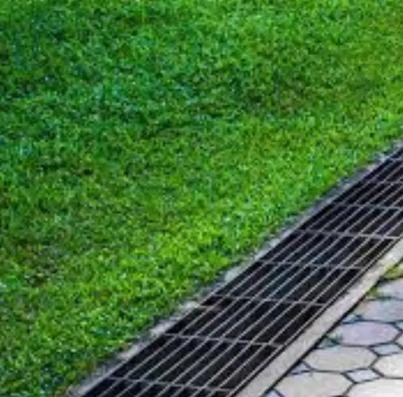 Effective surface water drainage solutions using a decorative NDS channel drain installed across a sloped driveway to prevent garage flooding.